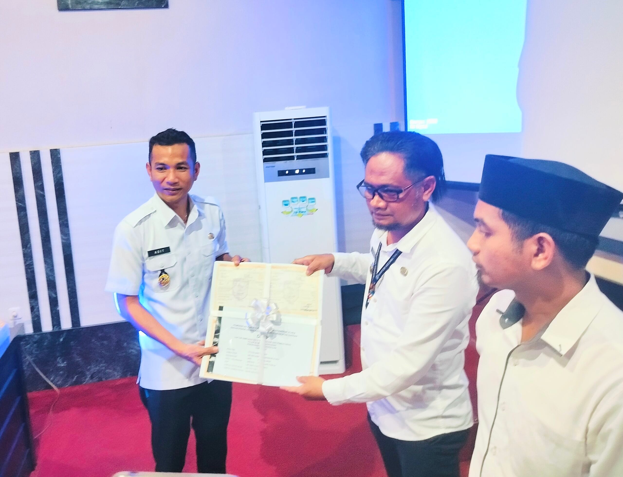 Wabub Aditya Pontoh menyerahkan secara simbolis SPPT PBB P2 kepala camat Pinogaluman 